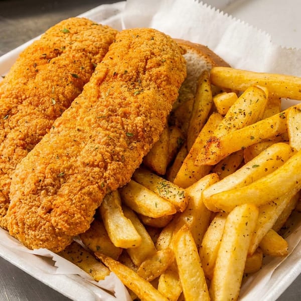 Crispy fried fish fillets and seasoned french fries in a white takeout container.